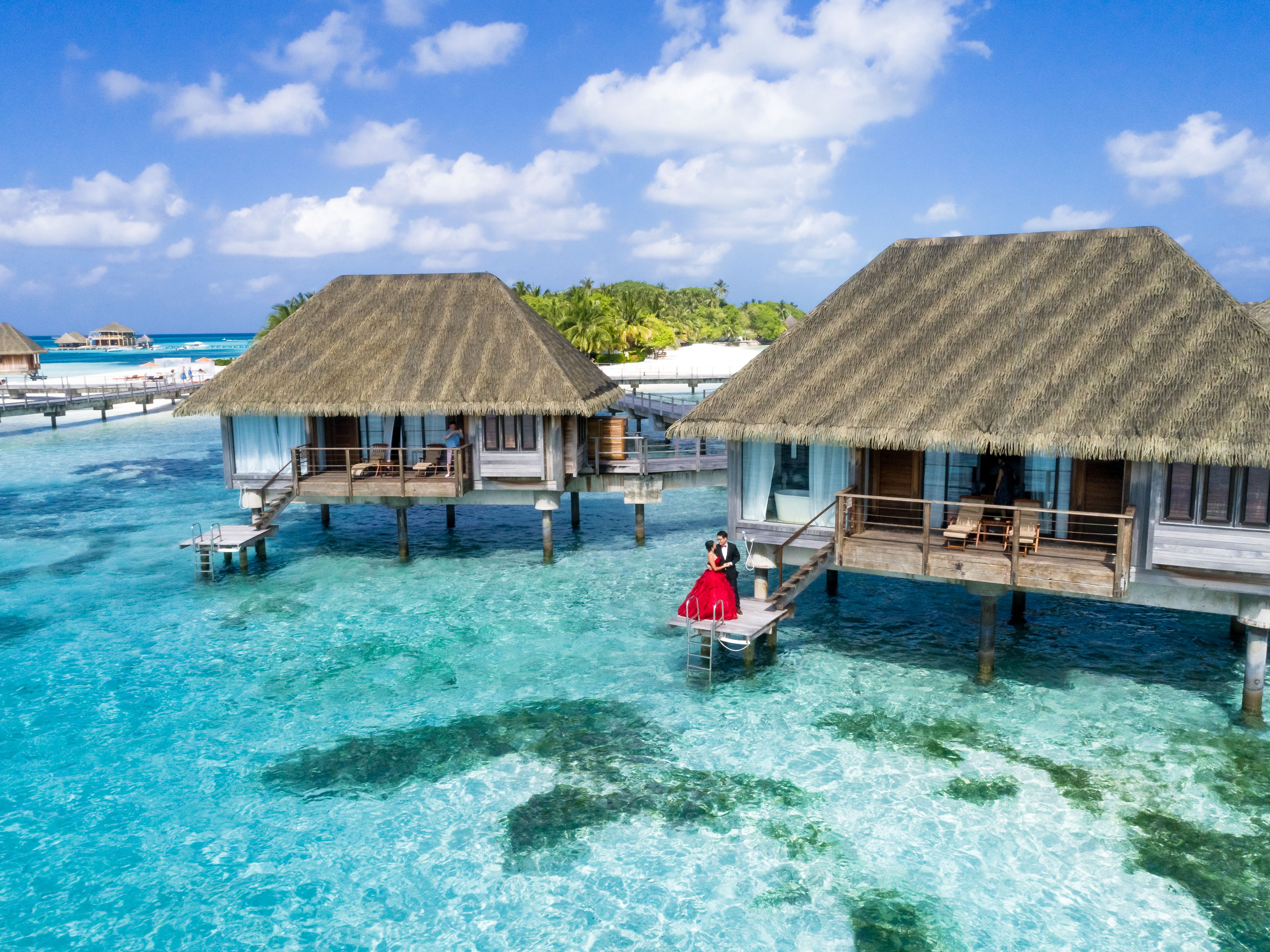 Maldives overwater villa at sunset representing a couples honeymoon trip cost